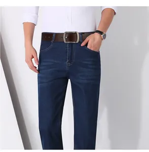 Detail of high-quality brown leather belt with brushed metal buckle on denim jeans