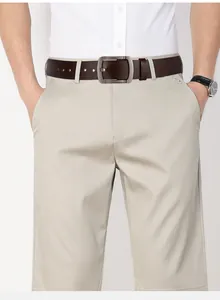 Detail of men's beige chinos with a classic dark brown leather belt and silver buckle