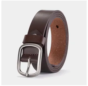 Détail d'une ceinture en cuir marron foncé avec boucle en métal argenté mat et couture fine
