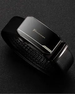 Close-up of black lychee grain leather belt with shiny automatic buckle and gold patterns