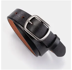 Détail d'une ceinture en cuir noir avec boucle argentée mate et grain texturé