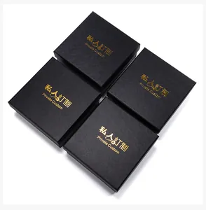 Details van vier zwarte vierkante geschenkdozen met textuur en gouden foliedruk
