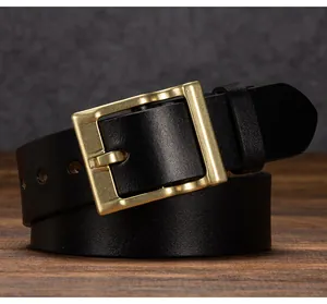 Dettaglio cintura in pelle nera vintage con fibbia in ottone antico e trama di alta qualità