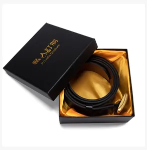 Detail van zwarte lederen riem met gouden gesp in luxe geschenkdoos met satijnen voering