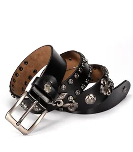 Dettaglio di cintura in pelle punk con borchie argentate ed emblemi in metallo a giglio