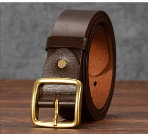 Detail of vintage dark brown leather belt with brushed brass square pin buckle