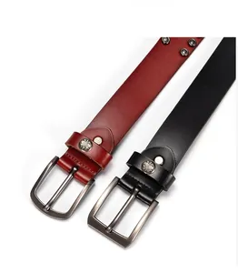 Dettagli macro delle cinture in pelle con borchie punk e accenti di stemmi metallici