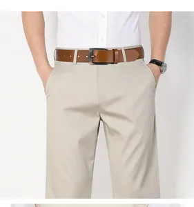 Dettaglio della cintura in pelle marrone con fibbia in bronzo su pantaloni casual kaki