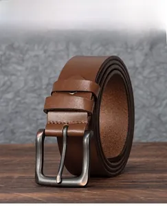 Détail d'une ceinture en cuir marron vintage avec boucle ardillon en métal vieilli
