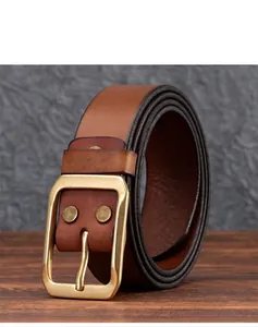 Dettaglio di cintura in pelle marrone vintage con fibbia ad ardiglione in ottone