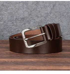 Macro view of vintage engraved alloy buckle and brown genuine leather belt for men
