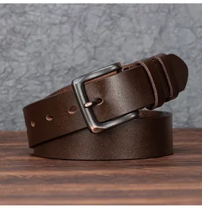 Détail d'une ceinture en cuir marron foncé vintage avec une boucle en métal brossé