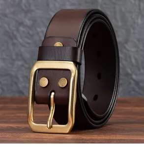 Dettaglio cintura in pelle vintage marrone con fibbia in ottone e rivetti metallici