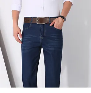 Close-up of a brown leather belt with a metal pin buckle worn on dark blue jeans