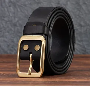 Dettaglio della fibbia in ottone vintage su cintura da uomo in vera pelle nera retrò