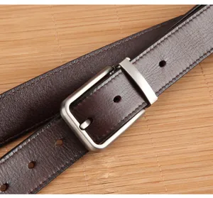 Detail of dark brown leather belt featuring matte silver buckle and fine edge stitching