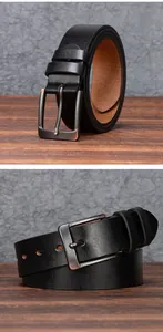 Dettaglio della cintura vintage in pelle nera con fibbia opaca su legno scuro