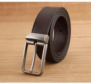 Macro detail of brown leather belt with matte silver metal buckle on natural bamboo mat