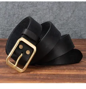 Dettaglio di una cintura vintage in pelle nera con fibbia in ottone e rivetti