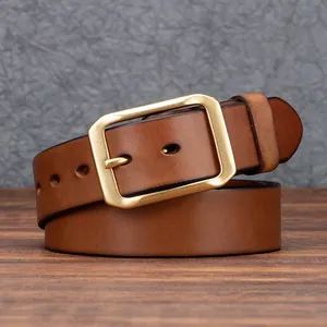 Cintura vintage in pelle marrone con fibbia in ottone su sfondo rustico