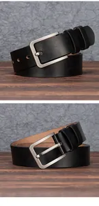 Detail of black leather belt with matte silver metal buckle on rustic wooden surface