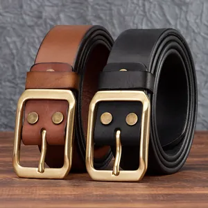 Cinture in pelle vintage marrone e nera con fibbia in ottone massiccio su tavolo di legno
