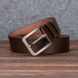 Classic men's brown genuine leather belt with matte silver buckle on wooden background