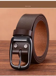 Detail of dark brown leather belt with matte black buckle and vintage rivets on wood