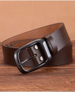 Detail of vintage dark brown leather belt with matte black buckle on wood
