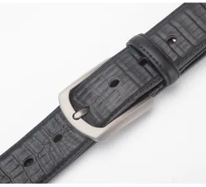 Detailed macro view of black embossed leather belt with brushed metal pin buckle