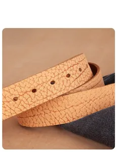 Macro detail of brown textured leather belt showing precise nine-hole punch craftmanship