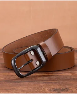 Close-up of a vintage dark brown leather belt with gunmetal pin buckle on wood
