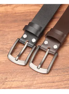 Detail of black and brown leather belts with gunmetal buckles and decorative silver rivets