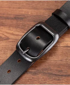 Close-up of vintage black leather belt featuring a matte gunmetal pin buckle and texture
