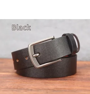 Close-up of black leather belt with brushed metal pin buckle on wooden surface