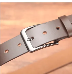 Dettaglio di una cintura in pelle marrone scuro vintage con fibbia ad ardiglione argento