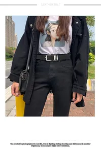 Détail d'une ceinture en cuir noir avec boucle carrée argentée et trois passants en métal