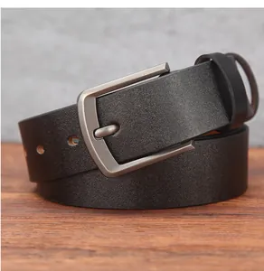 Close-up of matte black leather belt with a vintage silver metal pin buckle on wood
