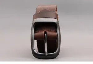 Detail of vintage dark brown leather belt with matte gunmetal buckle and hand-stitched seams