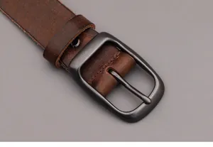 Close-up of vintage dark brown genuine leather belt with matte black metal pin buckle