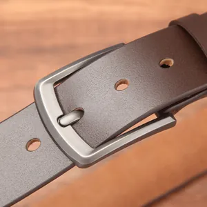 Classic dark brown genuine leather belt with matte metal buckle on a rustic wooden background