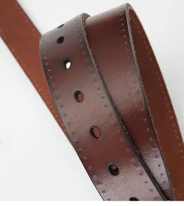 Macro shot of dark brown leather belt showing detailed grain and decorative stitching