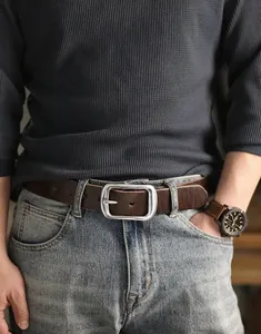 Dettaglio di una cintura in pelle marrone vintage con fibbia ad ardiglione argento