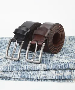 Détail de ceintures en cuir noir et marron avec boucles en métal brossé sur du tissu