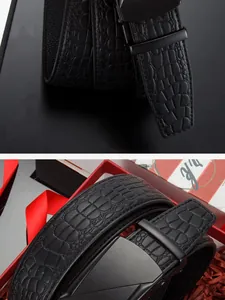 Détail de ceinture homme en cuir noir façon crocodile avec boucle mate et boîte cadeau