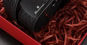 Détail de la ceinture en cuir gaufré crocodile avec boucle noire dans un coffret cadeau