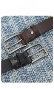 Gros plan d'une ceinture en cuir vintage avec couture fine et boucle argentée mate