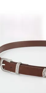 Detailed view of a brown vintage leather belt with ornate silver engraved metal buckle
