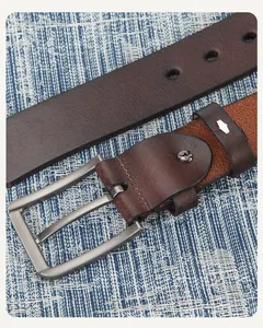 Détail d'une ceinture en cuir marron foncé avec grain naturel et boucle à ardillon mate