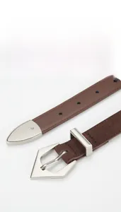 Detailed view of dark brown suede leather belt with silver geometric buckle and metal tip